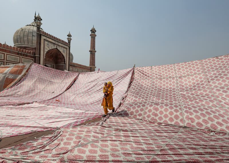 A child is carried after Ramadan prayers at Jama Masjid in Delhi on April 29. Reuters