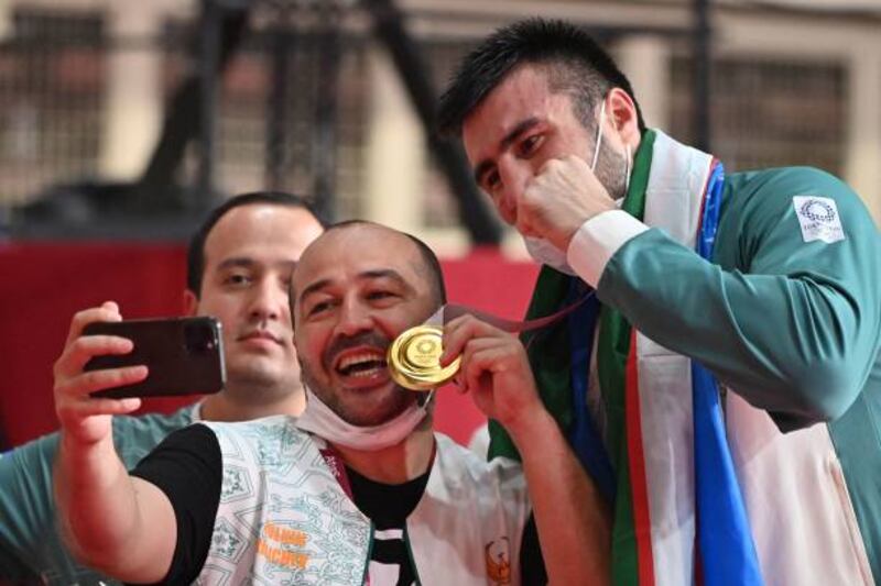 Uzbekistan gold medallist Bakhodir Jalolov poses with fans after the victory ceremony for the men's super heavy (over 91kg) boxing final bout during the Tokyo 2020 Olympic Games at the Kokugikan Arena in Tokyo.