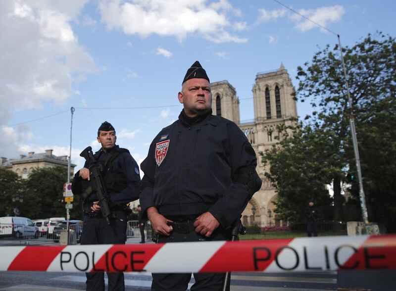 Police officers seal off the access to Notre Dame cathedral, seen in the background, after a man attacked officers with a hammer outside the famous landmark, in Paris, France, on June 6. Christophe / AP Photo