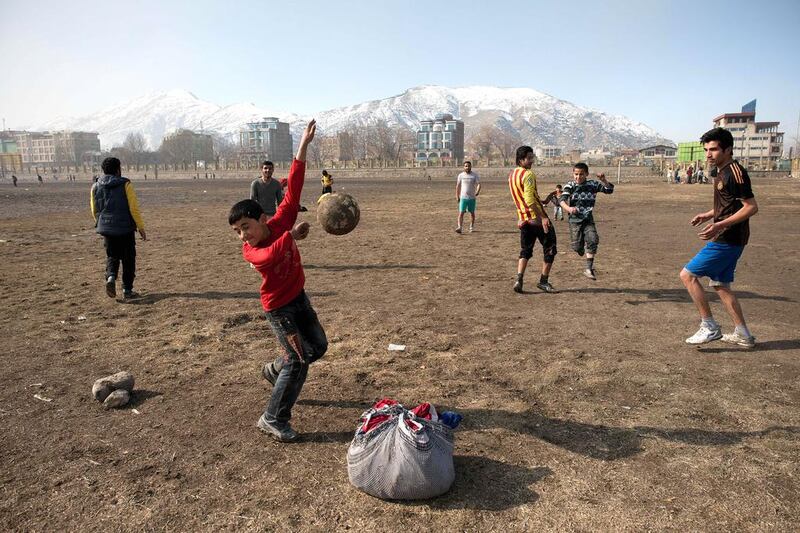 Afghan youths play football next to the Ghazi stadium in Kabul on February 15, 2014. AFP