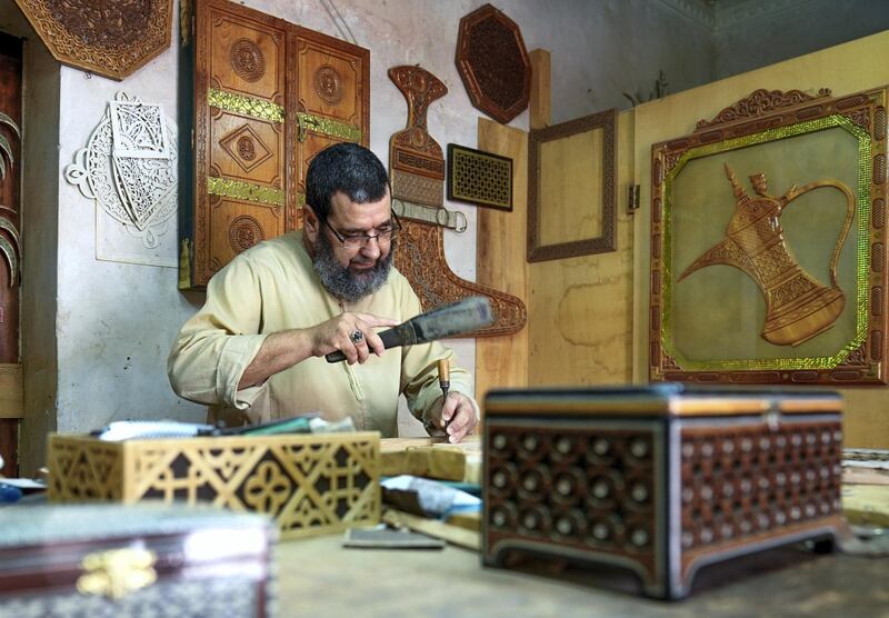 Abu Dhabi, United Arab Emirates, July 23, 2019.  VB:  Photo project at the Heritage Village, Corniche.  Local craftsworkers conduct workshops in traditional wood carving, metalwork, pottery, glass blowing and Arabic cloak making. --  Abdul Aziz- 57, grew up in Morocco and been a wood artist for 40 years now.  He has lived and worked at Abu Dhabi for 20 years already.
Victor Besa/The National
Section:  NA
Reporter: