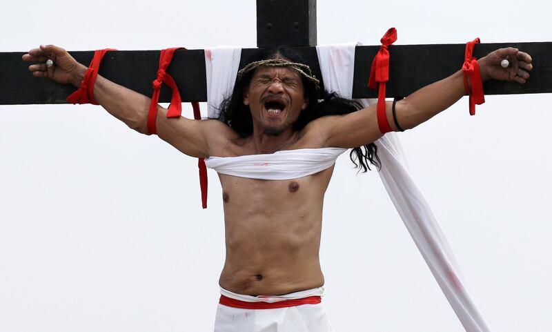Ruben Enaje grimaces after gets nailed to the cross for the 32nd year in a row during a re-enactment of Jesus Christ's sufferings as part of Good Friday rituals in the village of San Pedro Cutud, Pampanga province, northern Philippines. Aaron Favila / AP Photo