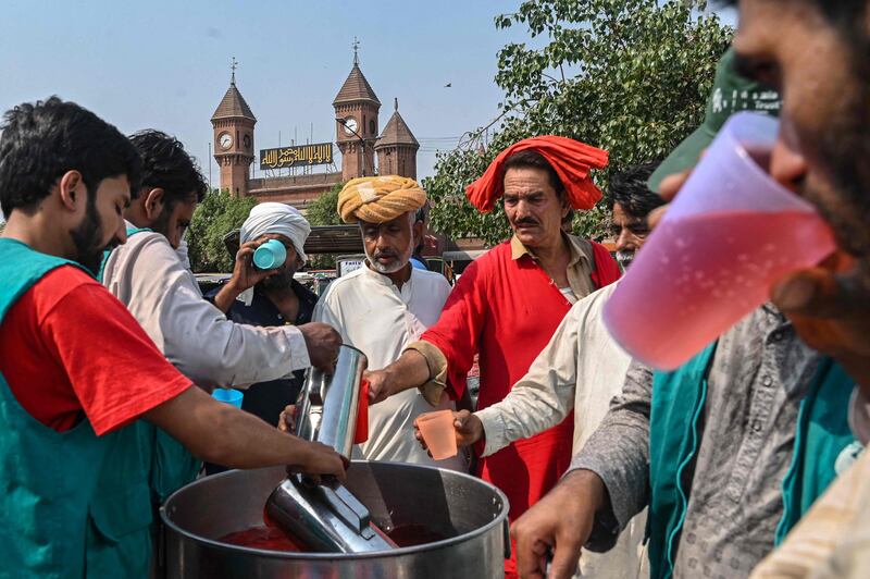 Volunteers distribute cold drinks to bypassers at a 'heatwave relief camp' along the road during a hot summer day in Lahore in May. AFP