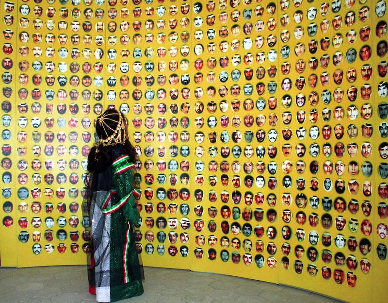 A young girl in Kuwaiti national dress looks up at pictures of hundreds of people missing since the 1990-1991 Gulf Crisis, on display at a major celebration marking the end of Iraq's occupation of Kuwait 10 years ago, in Kuwait City, February 25, 2001. Kuwait says the missing are in Iraqi prisons but Baghdad denies knowledge of their whereabouts. [Former U.S. President George Bush was among several foreign guests who gathered in Kuwait to celebrate the 10th anniversary of the end of the Gulf War.] Reuters
