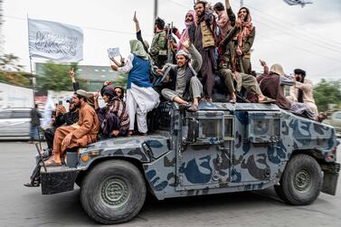 Taliban fighters hold weapons as they ride on a humvee to celebrate their victory day near the US embassy in Kabul on August 15, 2022.  - Taliban fighters chanted victory slogans next to the US embassy in Kabul on August 15 as they marked the first anniversary of their return to power in Afghanistan following a turbulent year that saw women's rights crushed and a humanitarian crisis worsen.  (Photo by Wakil KOHSAR  /  AFP)