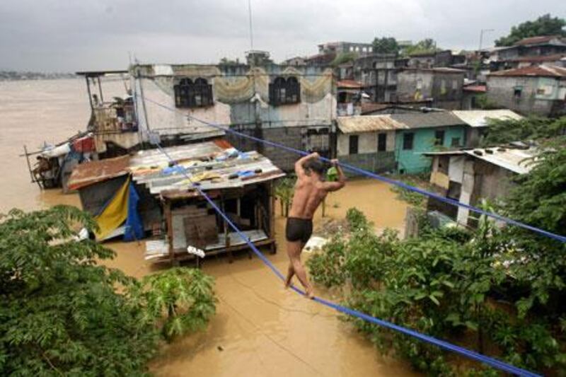 A Filipino man walks on a rope line to a rooftop in Pasig City, eastern Manila.