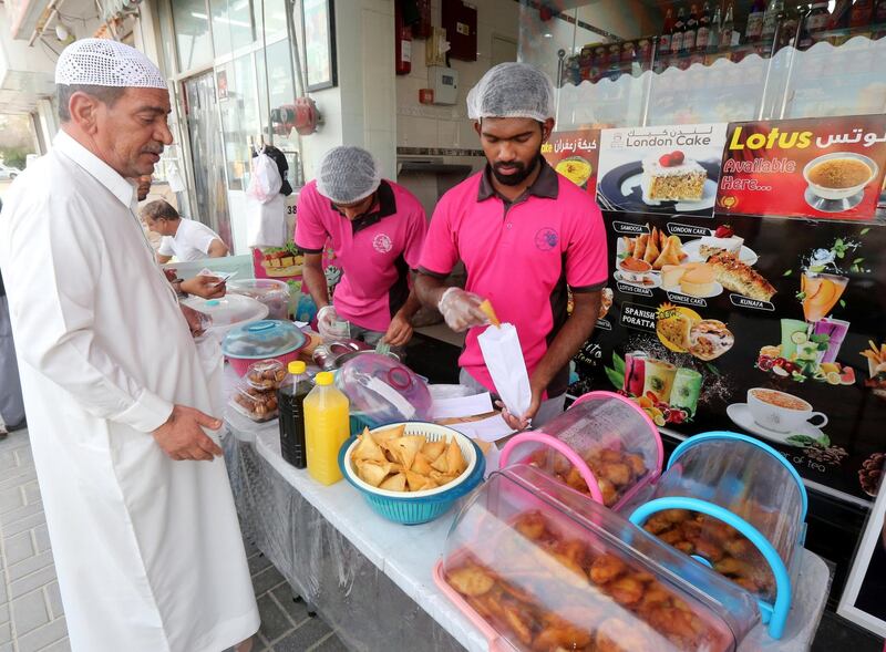 An Indian worker sells food to Emiratis during Ramadan, in the neighborhood of Al Quoz in Dubai. Reuters