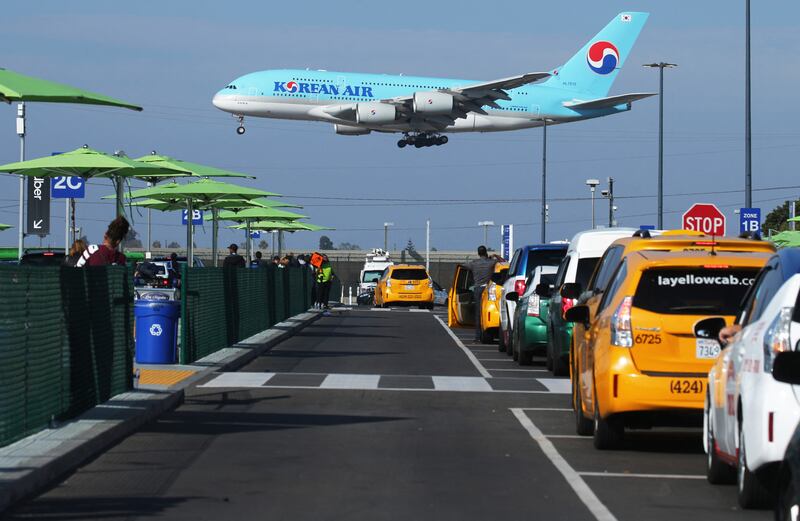 A Korean Air plane lands as taxis are lined up at the new 'LAX-it' ride-hail passenger pickup lot at Los Angeles International Airport in California. AFP