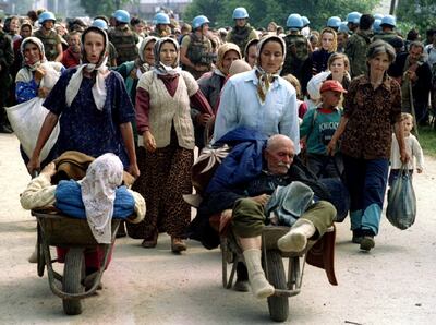 FILE PHOTO: Group of Bosnian refugees from Srebrenica, walk to be transported from eastern Bosnian village of Potocari to Kladanj near Olovo, July 13, 1995. Bosnia will mark the 25th anniversary of the massacre of more than 8,000 Bosnian Muslim men and boys on July 11, 2020, with many relatives unable to attend due to the novel coronavirus pandemic.  REUTERS/Stringer/File Photo