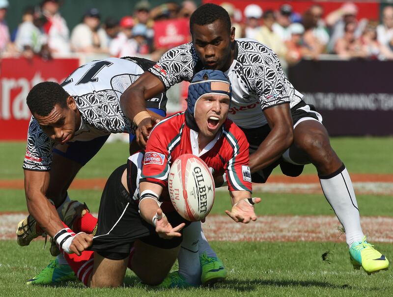 Dubai , United Arab Emirates, Dec 2 2011-UAE v Fiji- (centre) UAE's Tim Fletcher passes the ball as Fiji defenders  take him down near the try line during action at the Emirates Airlenes Dubai Rugby Sevens. Mike Young / The National
