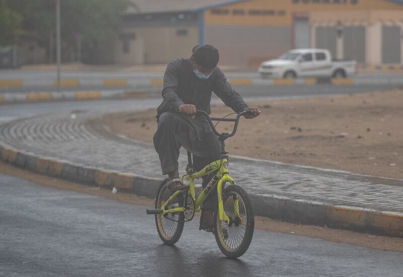 A man rides his bicycle during a brief downpour in the Mussaffah industrial area in Abu Dhabi. Victor Besa / The National