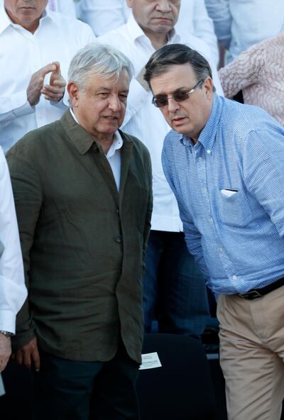 Mexican President Andres Manuel Lopez Obrador, left, speaks with Mexican Foreign Relations Secretary Marcelo Ebrard during a rally in Tijuana, Mexico, Saturday, June 8, 2019. Ebrard has told a cheering crowd near the U.S. border that his country emerged from high-stakes talks over U.S. tariffs "with its dignity intact." (AP Photo/Eduardo Verdugo)
