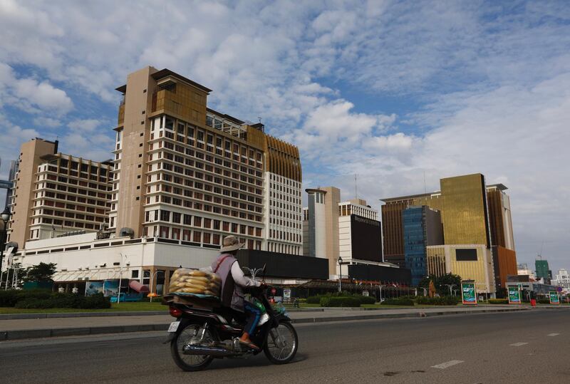 A Cambodian vendor rides a motorbike past the Nagaworld Casino in Phnom Penh, Cambodia.  EPA