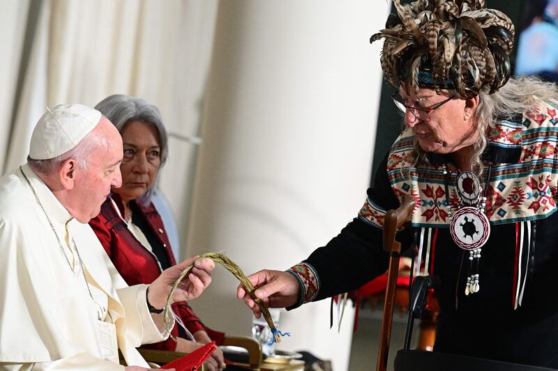 Pope Francis is presented with a gift. AFP