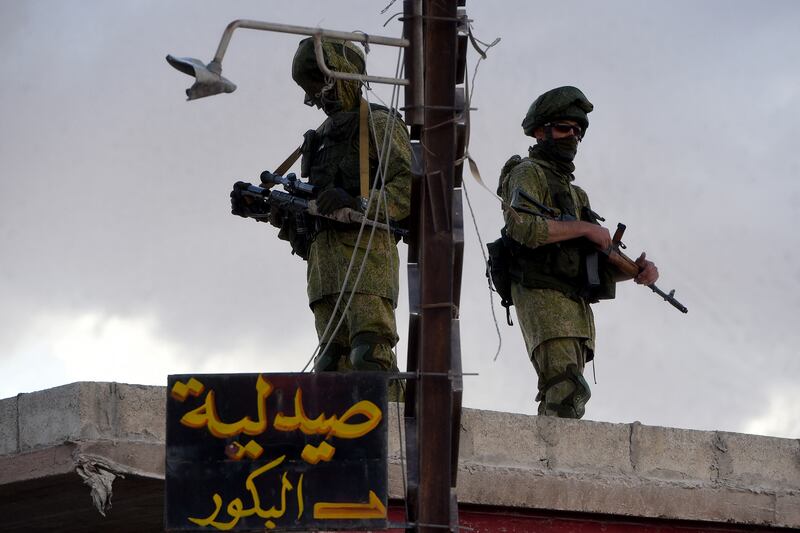 Russian soldiers on guard as a Russian military convoy passes through a small Syrian village near the city of Hama on May 4, 2016. AFP