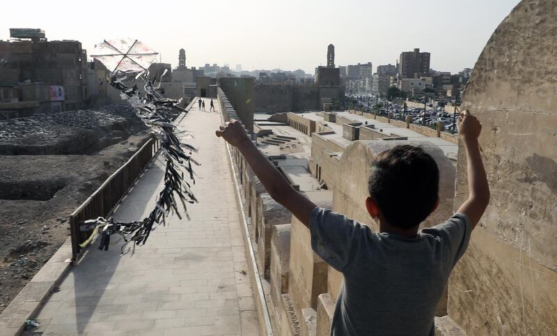 epa08418188 A boy flies a kite in Cairo, Egypt, 12 May 2020. Muslims around the world celebrate the holy month of Ramadan by praying during the night time and abstaining from eating, drinking, and sexual acts daily between sunrise and sunset. Ramadan is the ninth month in the Islamic calendar and it is believed that the Koran's first verse was revealed during its last 10 nights  EPA/KHALED ELFIQI