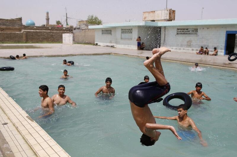 Iraqi Shi’ite youths play at a swimming pool in Sadr City.