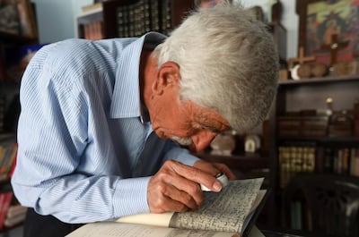 George Zaarour, a specialist in the Aramic language, uses a magnifying glass to decipher Aramaic script in the Syrian mountain village of Maalula, in the Damascus region on May 13, 2019. Today, "80 percent of Maalula's inhabitants don't speak Aramaic, and the remaining 20 percent are over 60 years old," said an expert.
Etched out in the cliff face, and full of churches, convents, and monasteries, Maalula is considered a symbol of Christian presence in the Damascus region. 
 / AFP / LOUAI BESHARA
