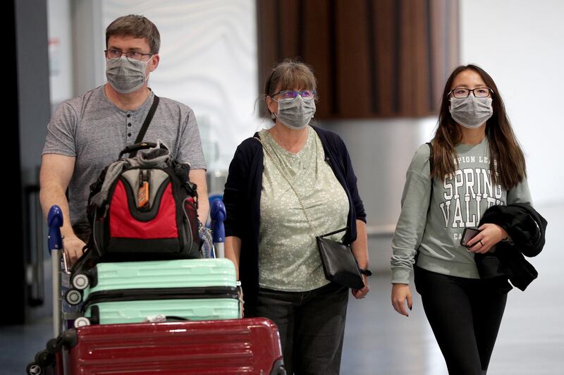 Passengers arriving on flights wear protective masks at the international airport in Auckland, New Zealand. Getty Images