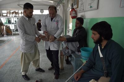 In this photograph taken on March 27, 2019, Afghan medical staff check the prosthetic leg of a landmine survivor at the International Committee of the Red Cross (ICRC) hospital for war victims and the disabled in Kabul. - According to the United Nations Mine Action Service (UNMAS), casualties from landmines and so-called "explosive remnants of war" have soared five-fold between 2012 and 2017, the last year full data was available. (Photo by WAKIL KOHSAR / AFP) / To go with story 'AFGHANISTAN-CONFLICT-LANDMINES' FOCUS by Laurent Abadie
