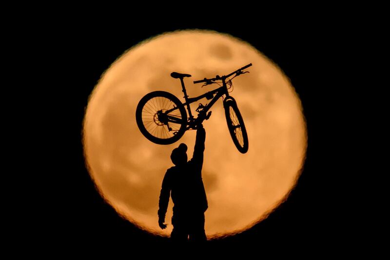 A BMXer lifts his bike in the air in front of the super moon near Salgotarjan, Hungary. EPA