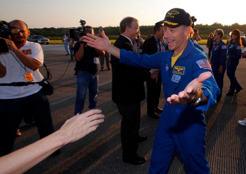 Space shuttle Atlantis Mission Commander Chris Ferguson (R) is greeted after landing at the Kennedy Space Center in Cape Canaveral, Florida, July 21, 2011. The 12-day mission to the International Space Station completes the last mission in the Space Shuttle Program. REUTERS/Scott Audette (UNITED STATES - Tags: TRANSPORT SCI TECH) *** Local Caption ***  KSC24_SPACE-SHUTTLE_0721_11.JPG