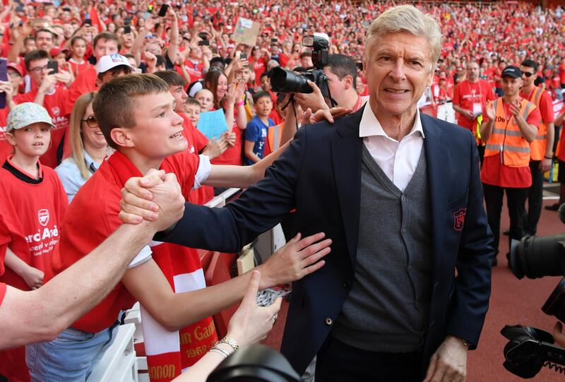Arsene Wenger shakes hands with an Arsenal fan. Mike Hewitt / Getty Images