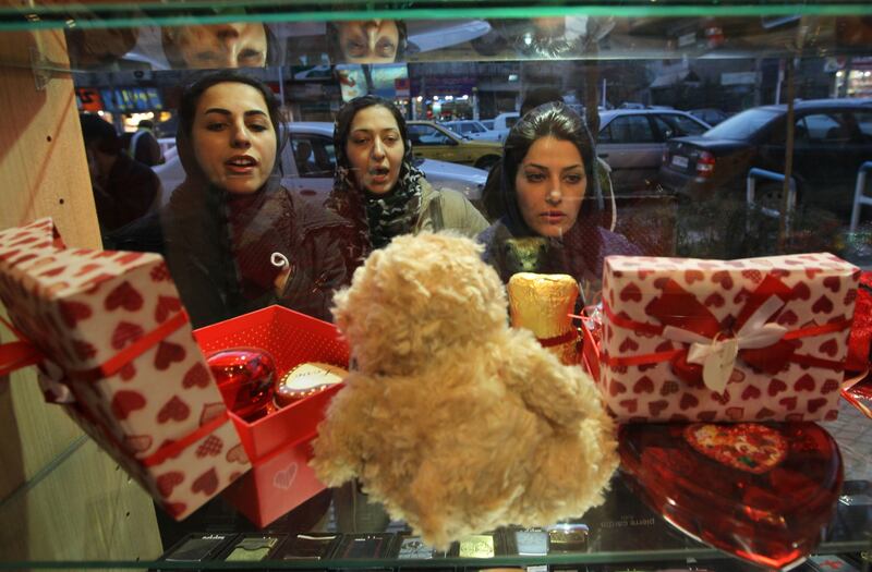 Iranian women look at Valentine's Day gifts on display in a shop window in Tehran on February 13, 2012. AFP PHOTO/ATTA KENARE
 *** Local Caption ***  862335-01-08.jpg