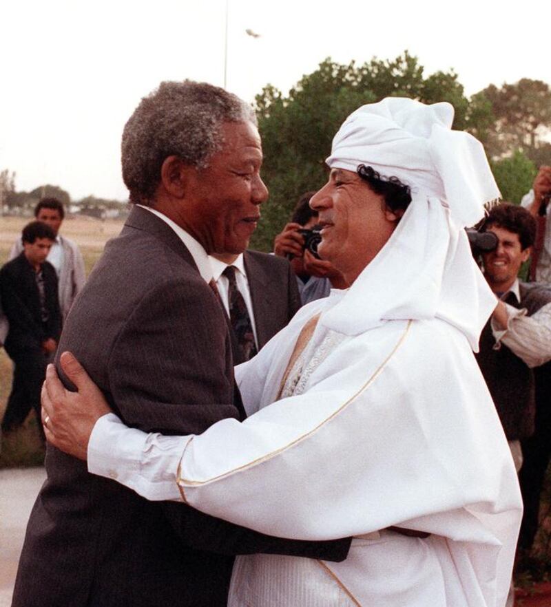 Then South African anti-apartheid leader and African National Congress member Nelson Mandela and Libyan leader Muammar Qaddafi hug upon Mandela's arrival to Tripoli in May, 1990.