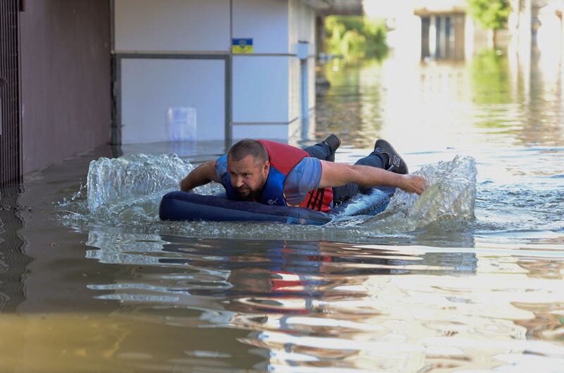 A resident on an inflatable mattress in a flooded area in Kherson. AFP