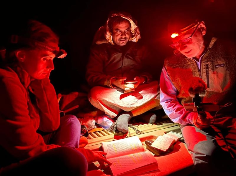 The team read by torch-light at night