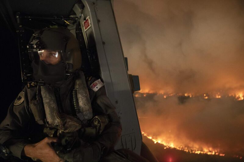 An aircrewman monitoring the Tianjara fire from a helicopter in the Moreton and Jerrawangala National Park in Moreton. AFP PHOTO / AUSTRALIA DEPARTMENT OF DEFENCE