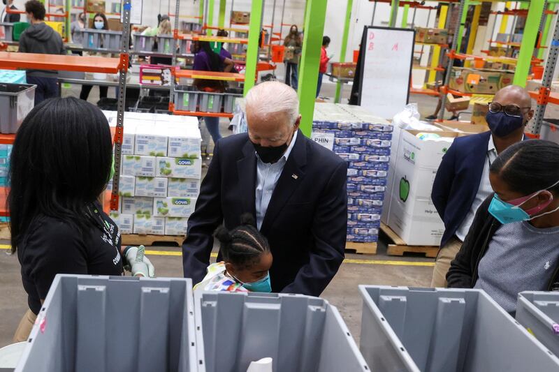 US President Joe Biden hugs a child as he visits the Houston Food Bank in Houston, Texas. Reuters