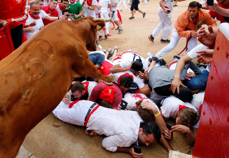 A wild cow leaps over revellers as it enters the bullring following the seventh running of the bulls at the San Fermin festival in Pamplona, northern Spain. Susana Vera / Reuters