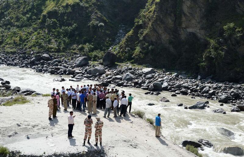 Indian rescuers gather on the banks of the Beas River during a search operation in Kullu on June 9, 2014. Rescuers discovered at least four bodies in the river after a sudden surge of water released from a dam swept students on a field trip away. AFP Photo