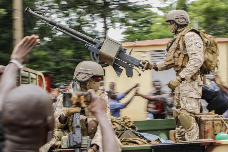 Malian soldiers parade as they arrive by military vehicle at Independence Square in Bamako. AFP