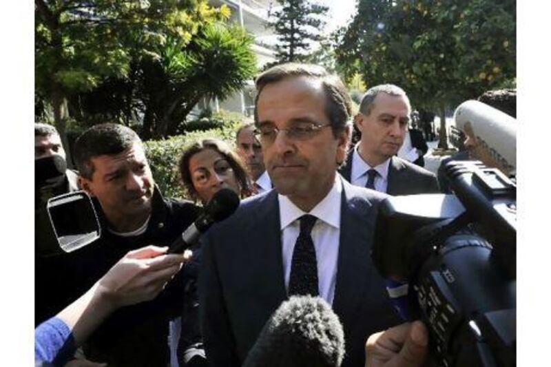 The leader of the main Greek opposition party, Antonis Samaras, centre, talks to reporters after his meeting with Greece's president in Athens yesterday.