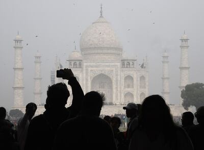 (FILES) In this file photo taken on January 03, 2018, visitors take a photo in front of the Taj Mahal in Agra.  Authorities have hiked fivefold ticket prices for Indian visitors to the Taj Mahal in the latest attempt to reduce visitor numbers to the country's top tourist site and reduce damage. / AFP / DOMINIQUE FAGET
