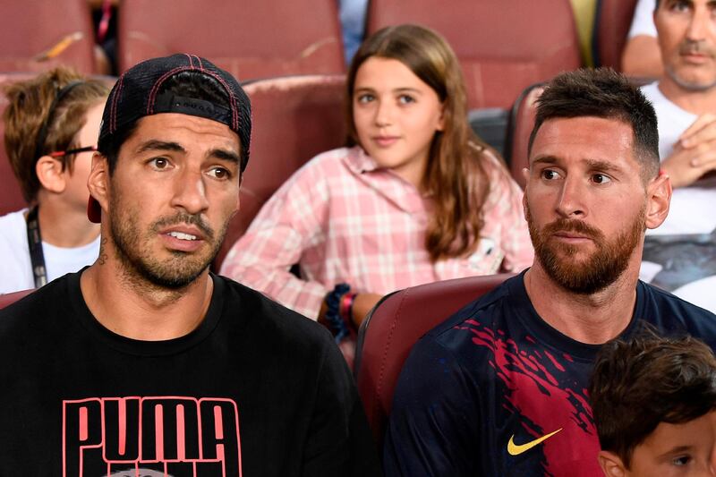 Barcelona forwards Luis Suarez, left, and Lionel Messi sit pitchside at Camp Nou during Barcelona's La Liga match against Real Betis on Saturday. AFP