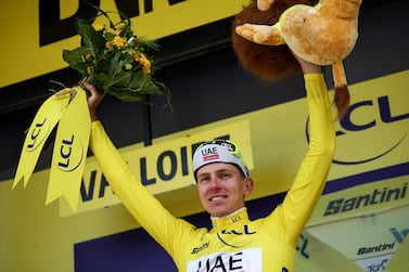 UAE Team Emirates team's Slovenian rider Tadej Pogacar celebrates on the podium with the overall leader's yellow jersey after the 4th stage of the 111th edition of the Tour de France cycling race, 140 km between Pinerolo in Italy, and Valloire in France, on July 2, 2024.  (Photo by Anne-Christine POUJOULAT  /  AFP)