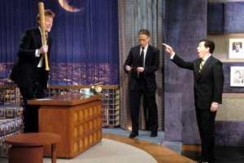 In this image released by NBC, Conan O'Brien, left, holds a bat on his show, "Late Night with Conan O'Brien" as Jon Stewart, center, from Comedy Central's "The Daily Show with Jon Stewart" and Stephen Colbert of "The Colbert Report" make an appearance on O'Brien's show, Monday, Feb. 4, 2008. (AP Photo/NBC, Dana Edelson)  ** NO SALES, MANDATORY CREDIT: NBC/Dana Edelson **  
