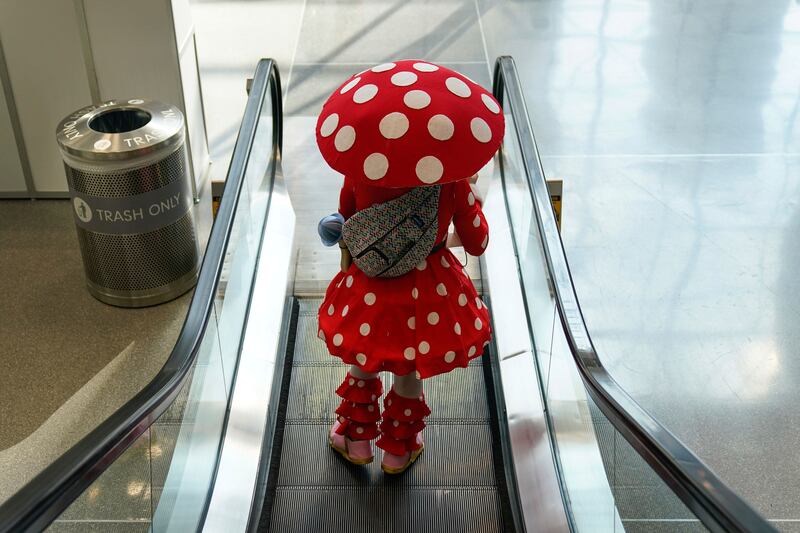 A woman in a mushroom costume rides an escalator at New York Comic Con. Seth Wenig / AP Photo