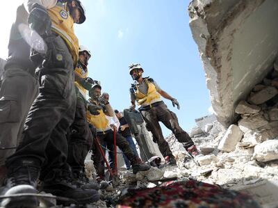 EDITORS NOTE: Graphic content / Members of the Syrian Civil Defence (White Helmets) uncover the body of a man killed in a collapsed building following a reported regime air strike on the town of Ariha, in the south of Syria's Idlib province, on July 12, 2019. At least a dozen civilians were killed in Syrian regime air strikes in the country's northwest, including three children, a war monitor said on July 12. / AFP / Omar HAJ KADOUR
