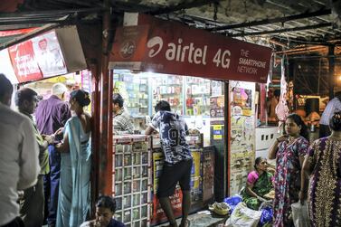 Advertisements for Bharti Airtel Ltd. are displayed above customers at a mobile phone store in Mumbai, India. Telecoms is one sector in which foreign direct investment declined. Bloomberg