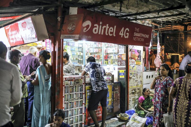 Advertisements for Bharti Airtel Ltd. are displayed above customers at a mobile phone store in Mumbai, India, on Saturday, April 21, 2018. Bharti Airtel are scheduled to release earnings on April 24. Photographer: Dhiraj Singh/Bloomberg