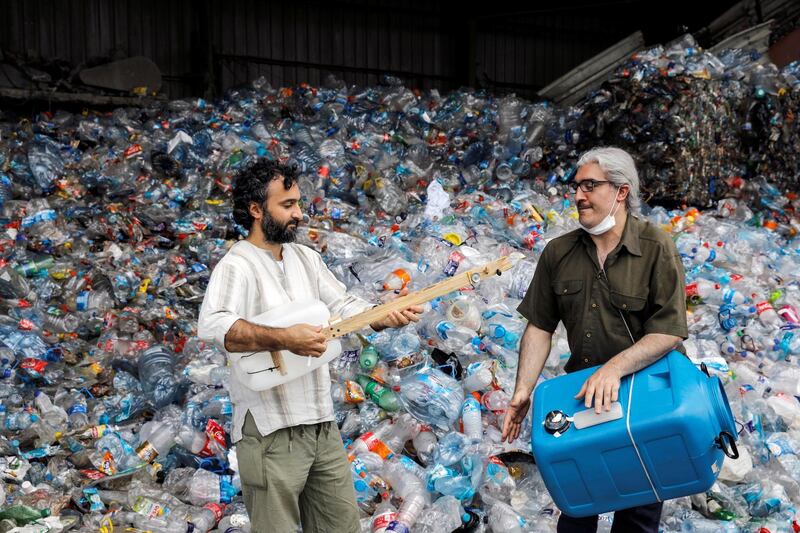 Musicians Roni Aran and Herman Artuc, members of the ethnic instrumental music band of Fungistanbul, perform with instruments made by materials collected from landfills, at a recycling depot in Istanbul. Reuters