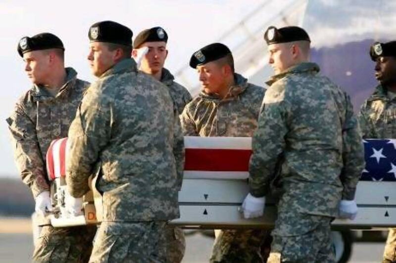 A US Army carry team carries the transfer case containing the remains of Sergeant Joshua Born of Niceville, Florida, upon arrival at Dover Air Force Base in Delaware on Saturday. The 25-year-old was shot dead by an Afghan soldier during a riot on Thursday over the burning of Qurans.