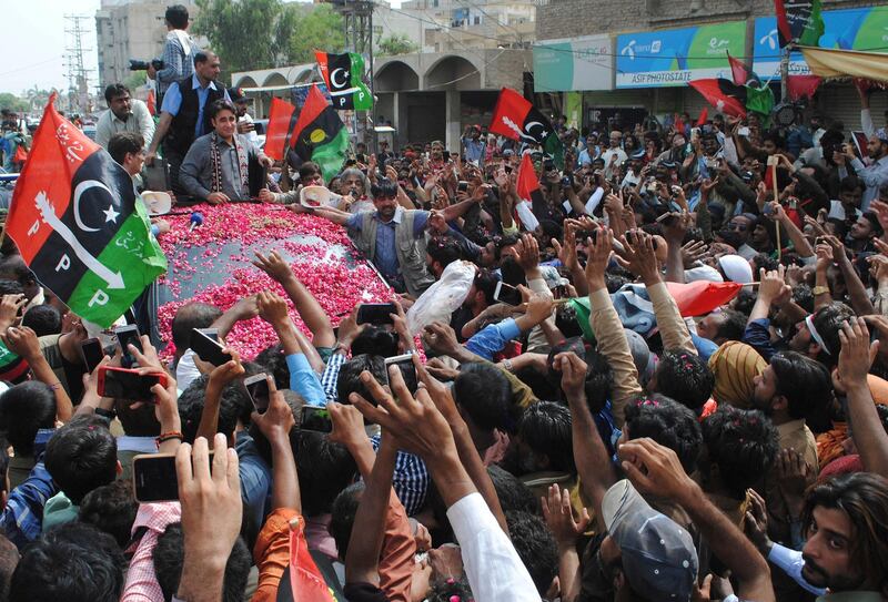 Supporters of Pakistan Peoples Party wave to their leader Bilawal Bhutto Zardari, standing on a truck during his election campaign in Hyderabad, Pakistan, Tuesday, July 3, 2018. (AP Photo/Pervez Masih)