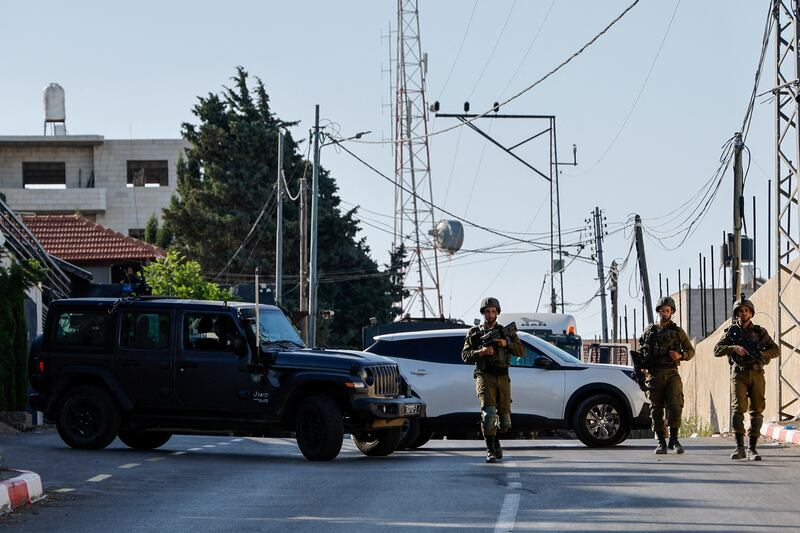 Israeli troops at the scene of the shooting, where three Palestinians were killed in Nablus. Reuters