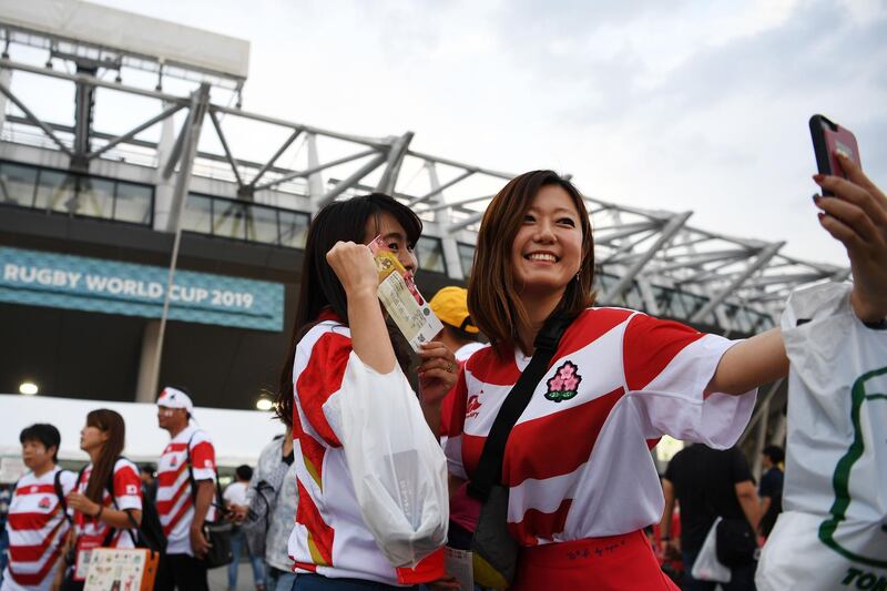 Fans pose for a selfie outside the Tokyo stadium. AFP